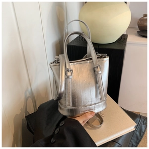 Close-up of metallic silver bucket bag with vertical texture and Fashion & Bags logo