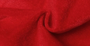 Macro detail of plush red velvet fabric texture for Christmas elf leg tree skirt