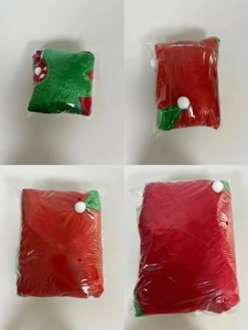Detail view of red and green Christmas elf leg tree skirt in clear plastic packaging