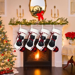 Set of four Christmas stockings with black cat and dog silhouettes on a cozy fireplace