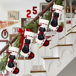 Close-up of cat and dog Christmas stockings with plaid bows on a white staircase