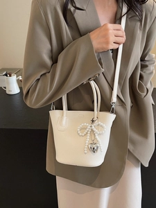 Creamy white bucket bag with pearl bow and heart charm for elegant women outfits