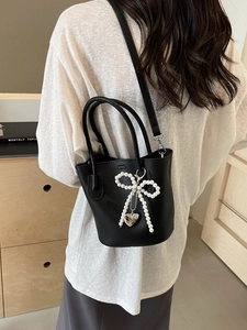 Fashionable black lychee textured bucket bag with pearl bow and heart charm details