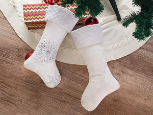 Close-up of white velvet Christmas stockings with silver sequined snowflake decorations