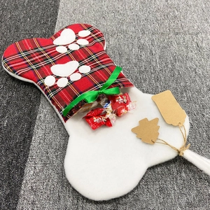 Detail of bone-shaped Christmas stocking with red-green plaid and plush white trim