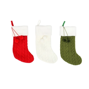 Tre calze natalizie in maglia con motivi a trecce e pompon in rosso bianco e verde