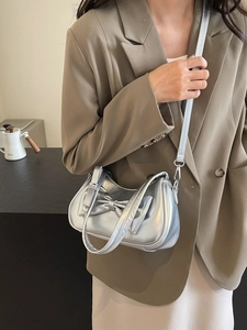Silver crescent moon shoulder bag with metallic finish and bow design for women