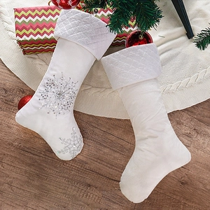 White leather Christmas stockings with silver sequin snowflakes for home holiday decoration