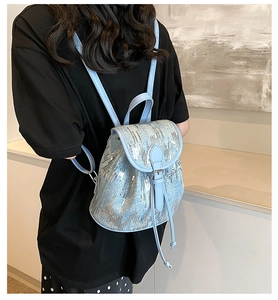 Détail du mini sac à dos à paillettes bleu clair avec cordon et boucle de fermeture à rabat