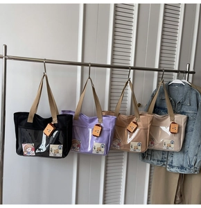 Detail of multi-color nylon tote bags with clear PVC pockets and cute biscuit charms