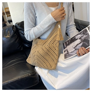 Détail du sac cabas beige tissé avec glands décoratifs et texture crochetée