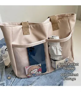 Detail showing two transparent front pockets on beige tote bag for phone and umbrella