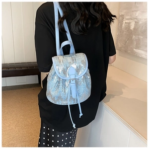 Détail du mini sac à dos à paillettes bleu clair avec rabat et cordon de serrage