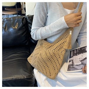 Détail d'un sac cabas beige crocheté à la main avec franges et design ajouré en coupe V