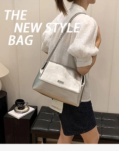 Silver metallic crossbody tote bag with chain strap shown in a modern lifestyle setting