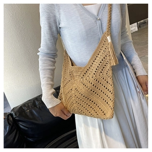 Détail de la texture crochet kaki et du pompon sur un grand sac cabas tissé à la main