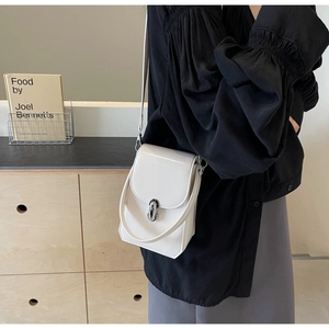 Détail d'un petit sac à main blanc brillant avec boucle métallique argentée et bandoulière