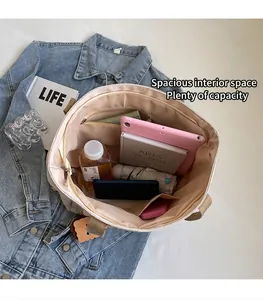 Detailed interior of a beige nylon tote showing multiple pockets and large storage capacity