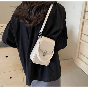 Détail du petit sac bandoulière crème avec boucle argentée et options de portage polyvalent