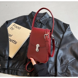 Vue détaillée du mini sac en cuir verni rouge foncé avec fermoir tournant en argent
