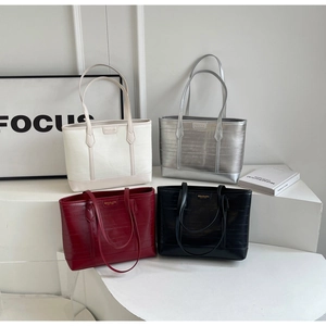 Detail view of large capacity textured tote bags in white, silver, burgundy and black