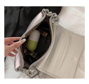 Spacious interior of silver metallic chain bag showing daily items and striped lining