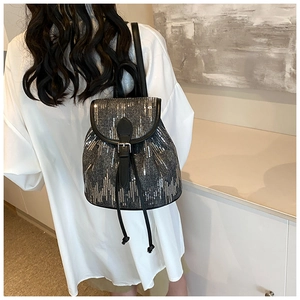 Détail du mini sac à dos à paillettes argentées avec bretelles en cuir sur mannequin