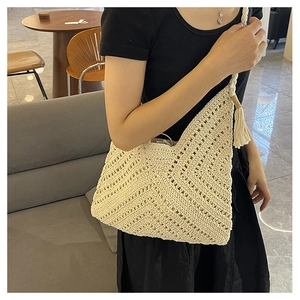 Détail du sac cabas beige ajouré au crochet avec texture tissée et décorations à franges