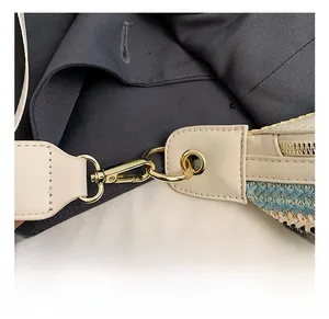 Close-up of golden hardware lobster clasp and blue woven straw texture on women bag