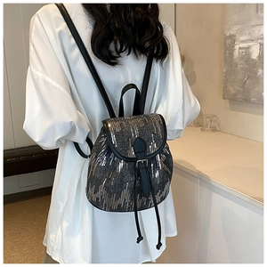 Détail du mini sac à dos avec paillettes argentées brillantes et bretelles en cuir noir