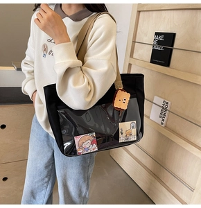 Detail of black nylon tote bag with transparent PVC pocket and cute plush charm