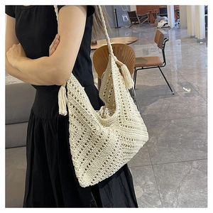 Détail de texture crochet ajourée et longues franges sur sac bandoulière tissé crème