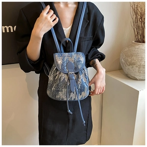 Détail du mini sac à dos à paillettes bleues avec cordon et lanières en cuir