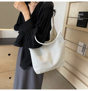 Detail of white woven texture on a large capacity shoulder tote bag for daily commute