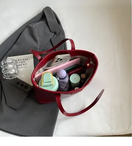 Internal view of the red leather tote bag showing large capacity and side zipper pocket
