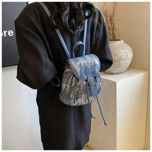 Détail d'un mini sac à dos bleu à paillettes pour femme avec boucle et cordon de serrage