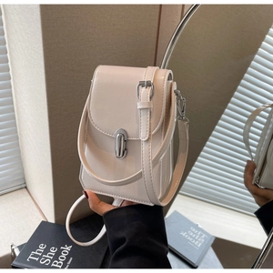 Détail du sac à téléphone crème avec fermoir argenté et bandoulière réglable