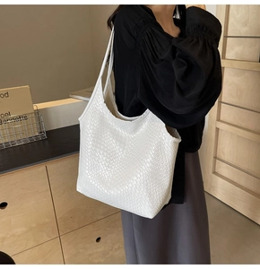 Close-up of white woven leather tote bag with dense texture and large interior capacity