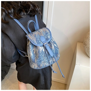 Vue détaillée du dos d'un mini sac à dos à paillettes bleues porté par un mannequin