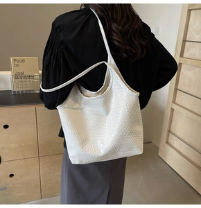 Detail of white woven faux leather tote bag showing textured pattern and spacious design