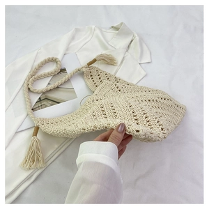 Détail du tissage au crochet ajouré crème avec pompon décoratif sur le sac à main