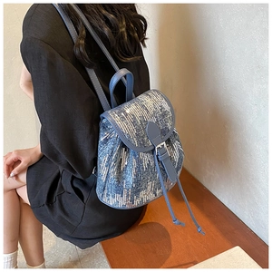 Mini sac à dos en jean porté avec paillettes dégradées bleues et fermeture à cordon