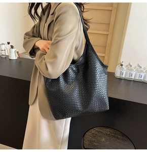 Detail of black woven textured tote bag showing high-quality synthetic leather finish