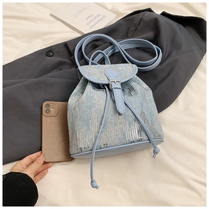 Détail du mini sac à dos en jean bleu clair avec paillettes argentées et cordon