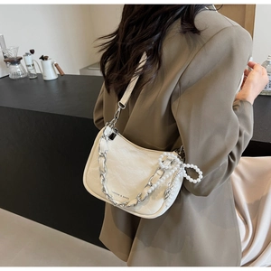 Detail of cream white leather shoulder bag with silver chain, pearls and bottom logo print