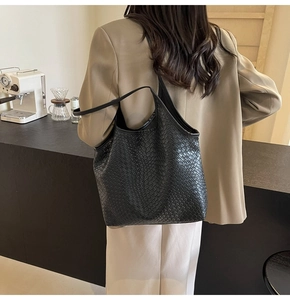 Detail of black woven tote bag showing the textured leather and soft large capacity design