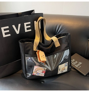 Detail of black nylon tote bag with transparent PVC pocket and cartoon insert card