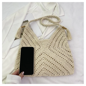 Détail du sac cabas beige tressé ajouré avec glands décoratifs et comparatif de taille
