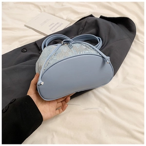 Détails du sac à main en denim bleu clair avec tissu scintillant et finitions en cuir