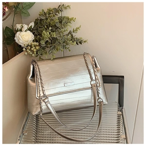Detail of silver metallic shoulder bag with horizontal embossing and chain strap